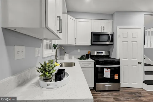 a kitchen with stainless steel appliances kitchen island granite countertop a stove a sink and a microwave