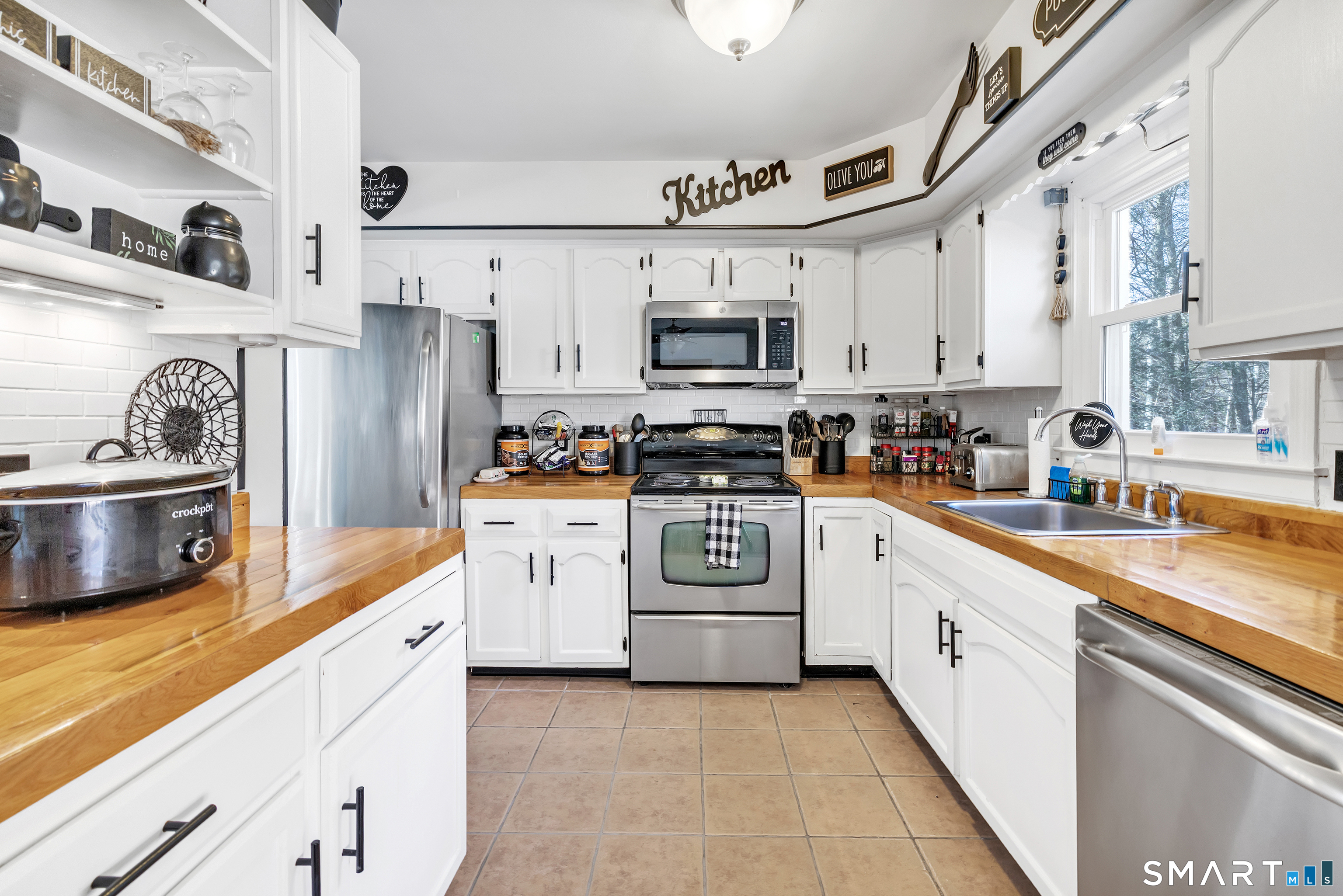 52 Cook Lane Beacon Falls, CT 06403 - Photo 12 of 24 a kitchen with stainless steel appliances granite countertop a sink a stove a refrigerator and white cabinets