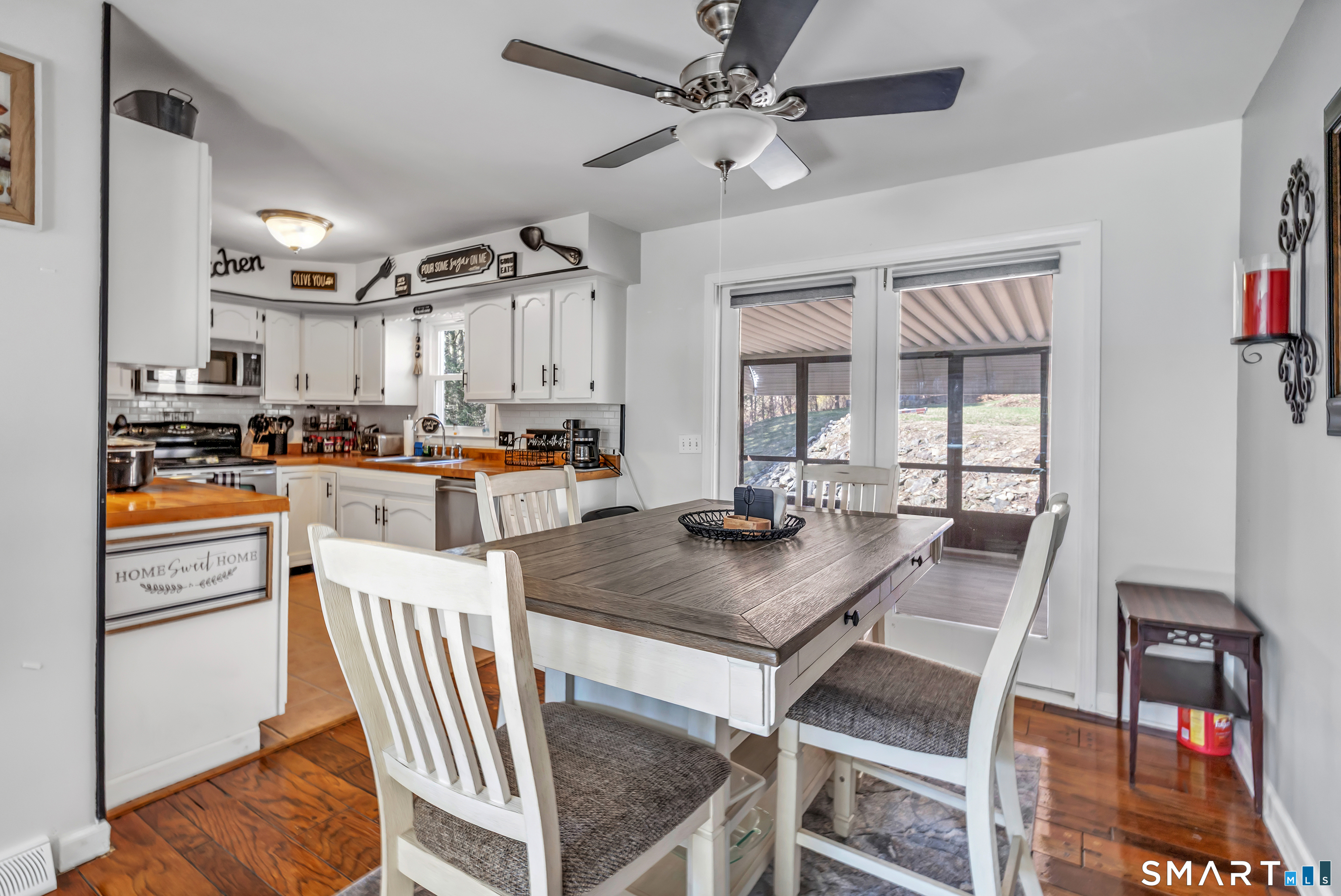 52 Cook Lane Beacon Falls, CT 06403 - Photo 8 of 24 a kitchen with stainless steel appliances granite countertop a stove a refrigerator a dining table and chairs with wooden floor