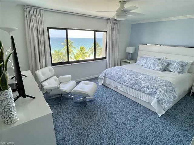 a bedroom with a bed and large windows