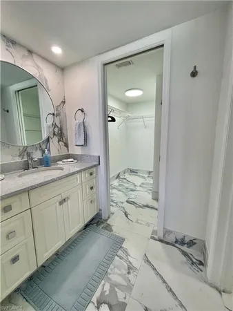 a spacious bathroom with a granite countertop sink and a mirror