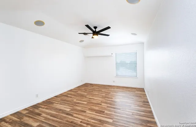 a view of a big room with wooden floor and a ceiling fan