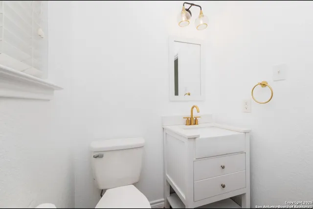 a bathroom with a sink a toilet and a mirror