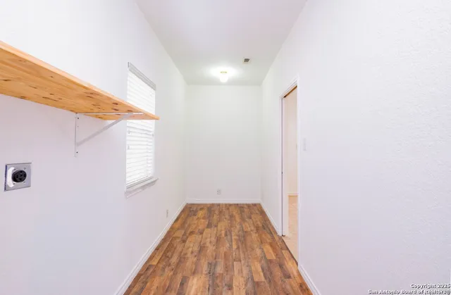 a view of a hallway with wooden floor