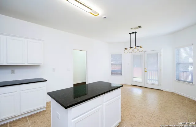 a kitchen with granite countertop a sink stainless steel appliances and cabinets