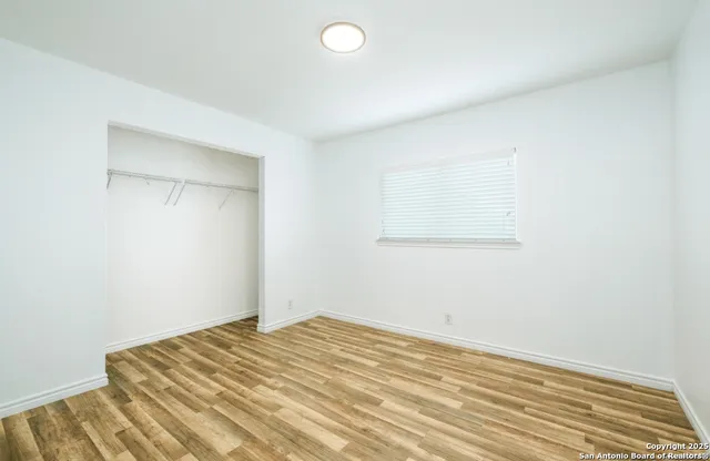 a view of a room with wooden floor and white walls