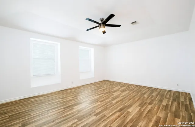 a view of empty room with wooden floor