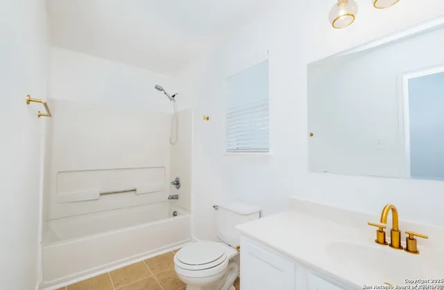 a bathroom with a bathtub shower sink vanity and toilet