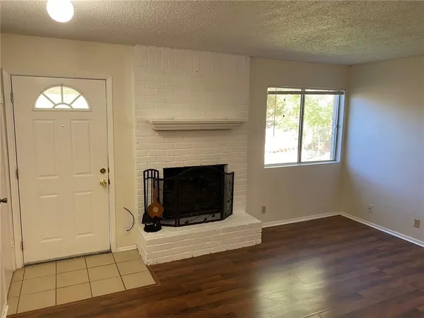 a view of a livingroom with wooden floor and a fireplace