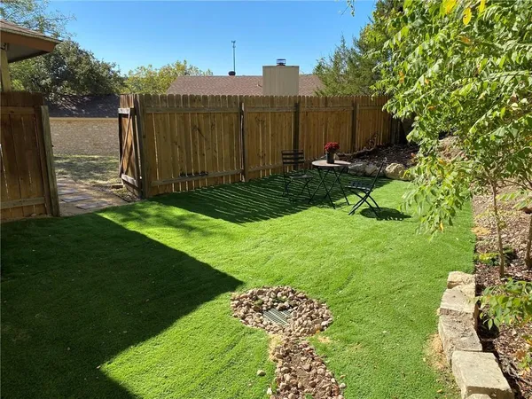 a view of a backyard with wooden fence