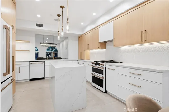 a kitchen with kitchen island a sink stainless steel appliances and cabinets