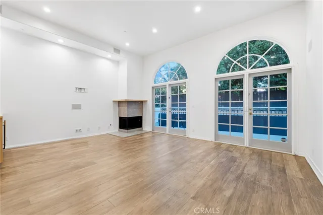 a view of empty room with wooden floor and window