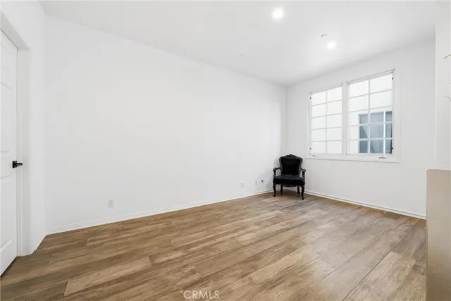 a view of empty room with wooden floor and small space