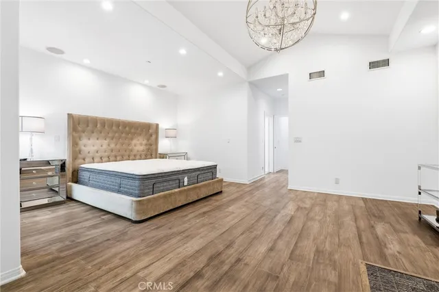 a bed sitting in a spacious bedroom next to a window