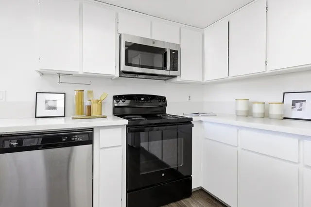 a kitchen with appliances a sink and cabinets