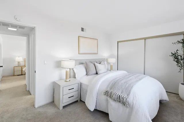 a spacious bedroom with a bed and a lamp