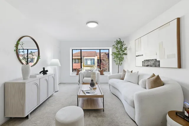 a living room with furniture a large window and a potted plant