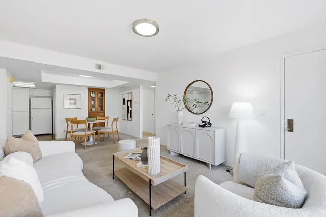 a living room with furniture a large window and a clock