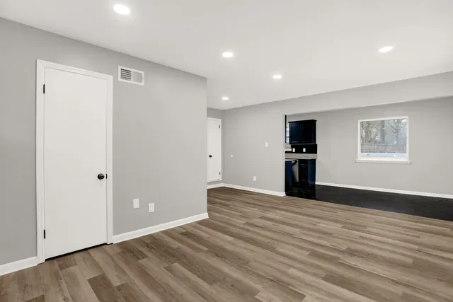 a view of empty room with wooden floor