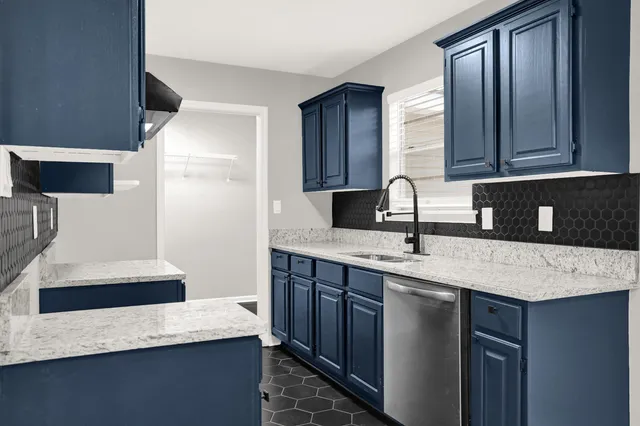 a kitchen with a sink a stove and a wooden cabinets