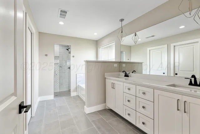 a spacious bathroom with a double vanity sink mirror and double