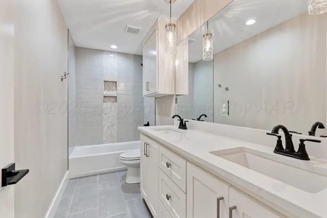 a bathroom with a sink a toilet a mirror and shower