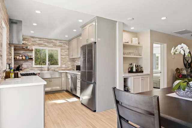 a kitchen with refrigerator a sink and chairs