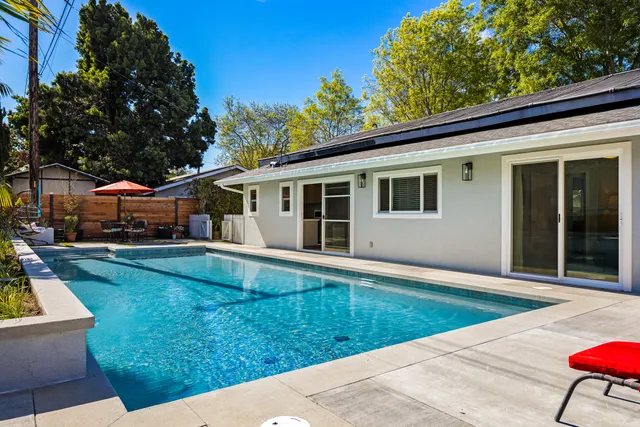 a view of a patio with table and chairs under an umbrella