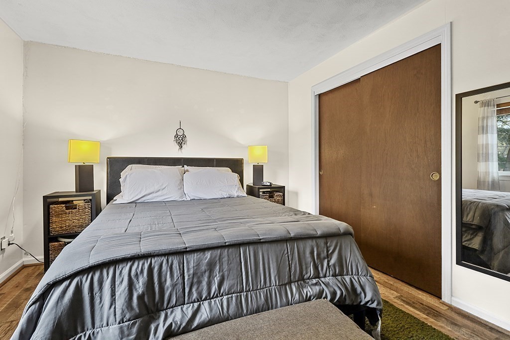 109 Maple Street, Unit E3 Attleboro, MA 02703 - Photo 16 of 18 a bedroom with a bed and wooden floor