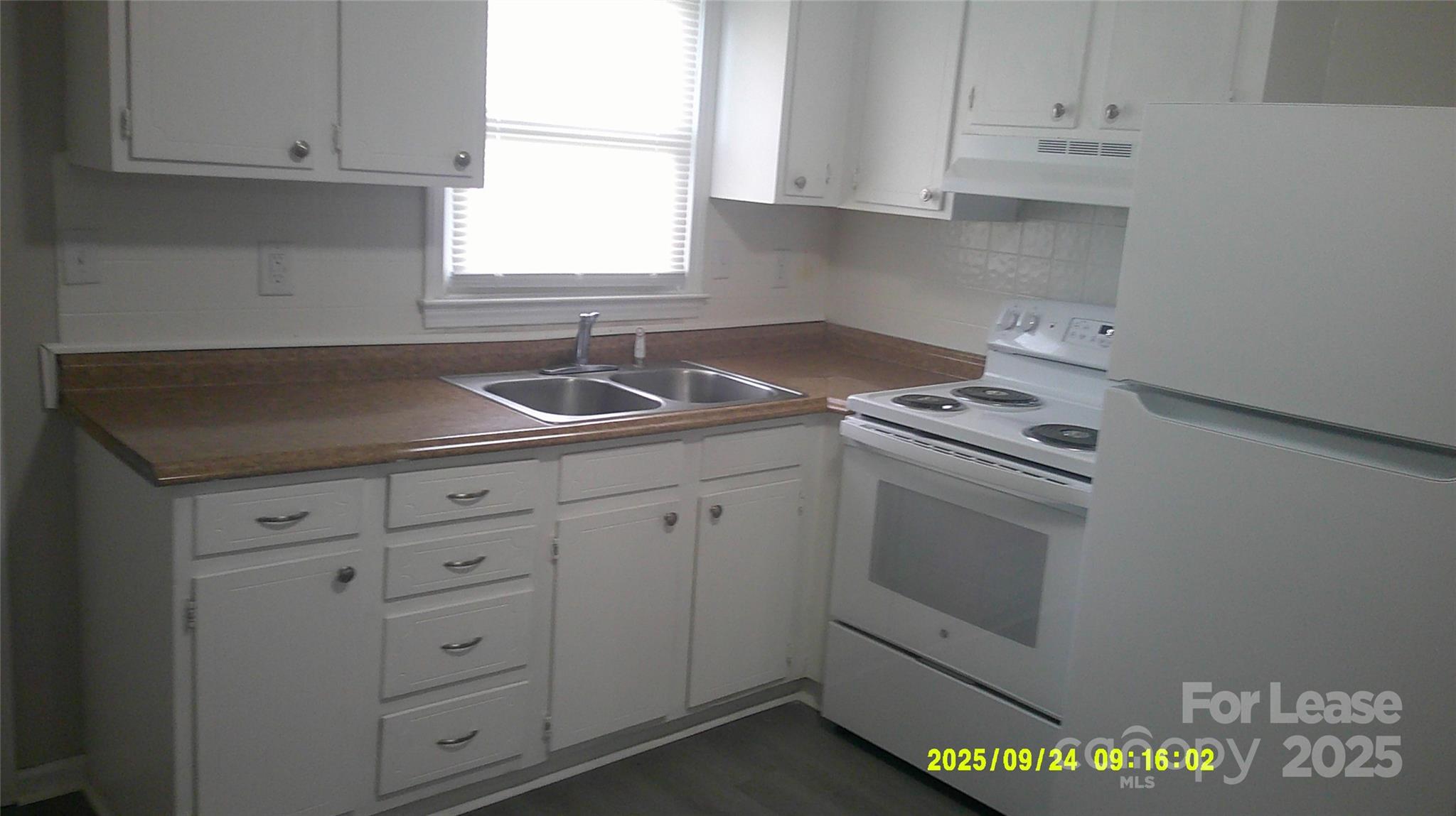 1326 7th Avenue Southwest Hickory, NC 28602 - Photo 5 of 11 a kitchen with white cabinets and white appliances