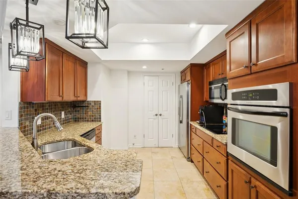 a kitchen with stainless steel appliances granite countertop a sink stove and refrigerator