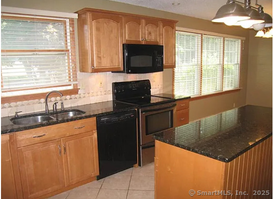 28 Lloyd Road Waterford, CT 06385 - Photo 6 of 16 a kitchen with granite countertop a sink stainless steel appliances a window cabinets and a counter top space