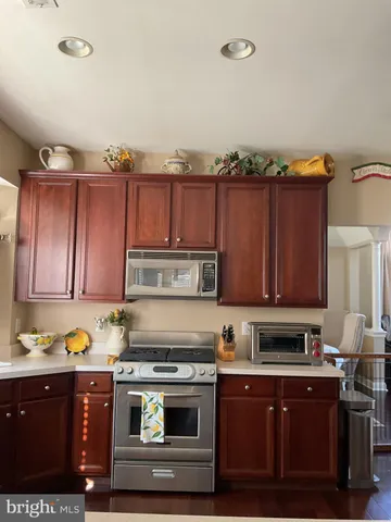 a kitchen with kitchen island granite countertop wooden cabinets and a stove