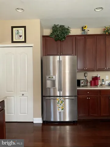 a kitchen with a refrigerator and wooden floor