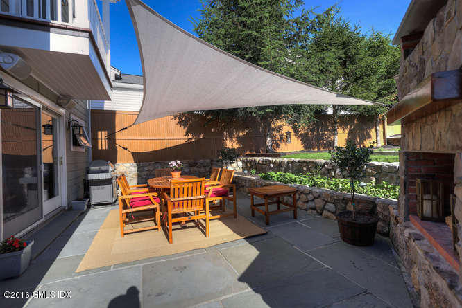 16 Apache Place Riverside, CT 06878 - Photo 12 of 27 a couple of tables and chairs under an umbrella in a patio