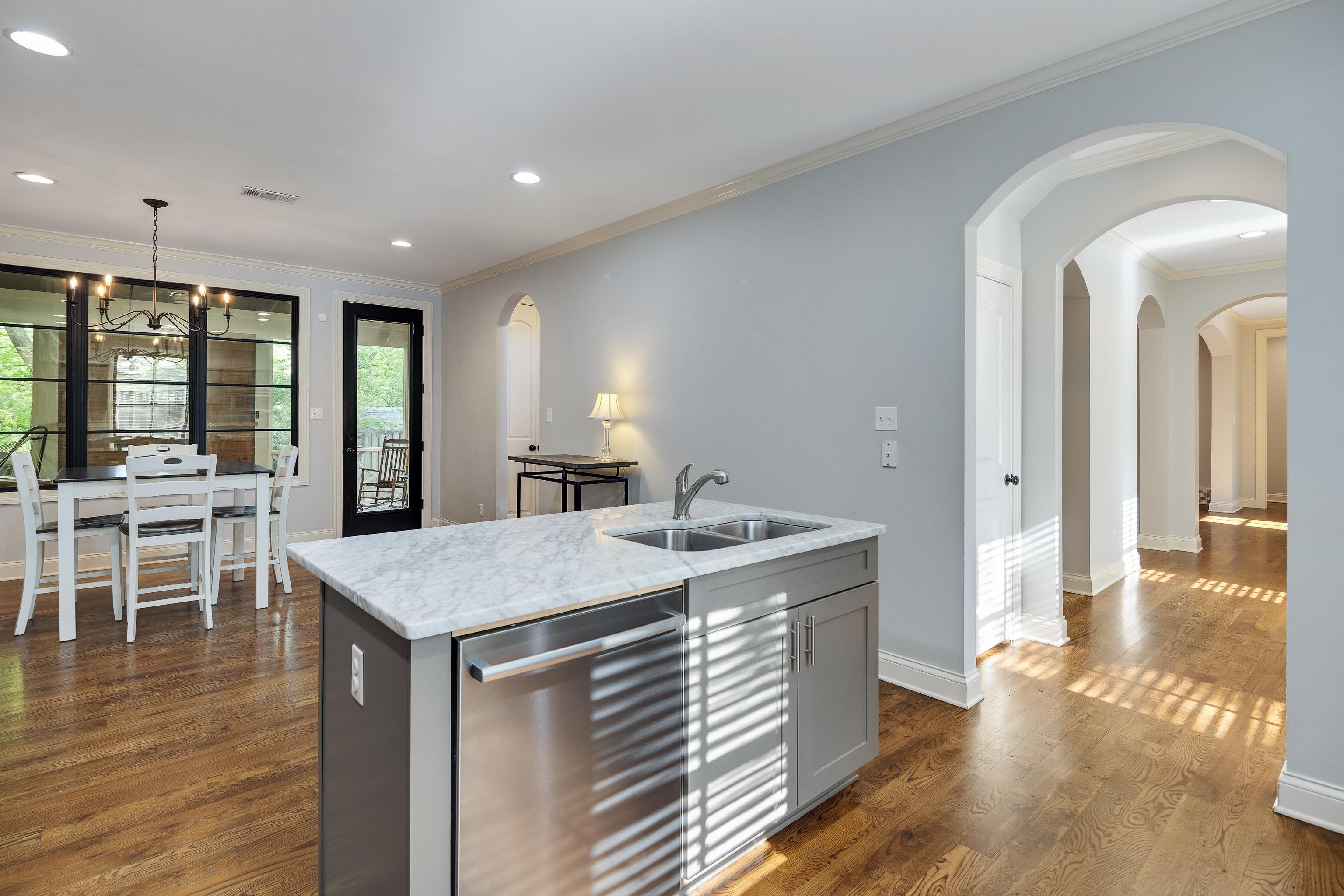 237 Windover Road Memphis, TN 38111 - Photo 18 of 37 Kitchen featuring gray cabinetry, stainless steel dishwasher, crown molding, an island with sink, and dark wood finished floors