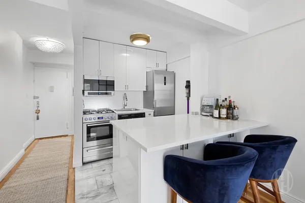 a kitchen with stainless steel appliances granite countertop a sink a stove a refrigerator and a refrigerator