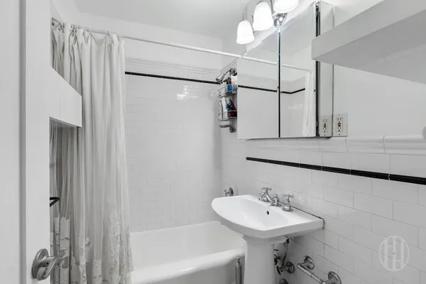 a bathroom with a sink mirror and shower