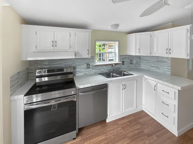 a kitchen with white cabinets stainless steel appliances and sink