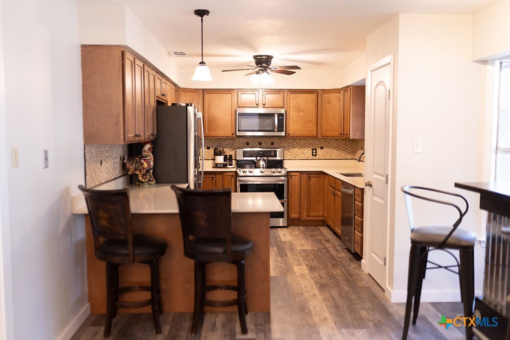 188 Cavalry Road Victoria, TX 77905 - Photo 11 of 26 a kitchen with stainless steel appliances granite countertop a stove top oven a refrigerator a sink and chairs