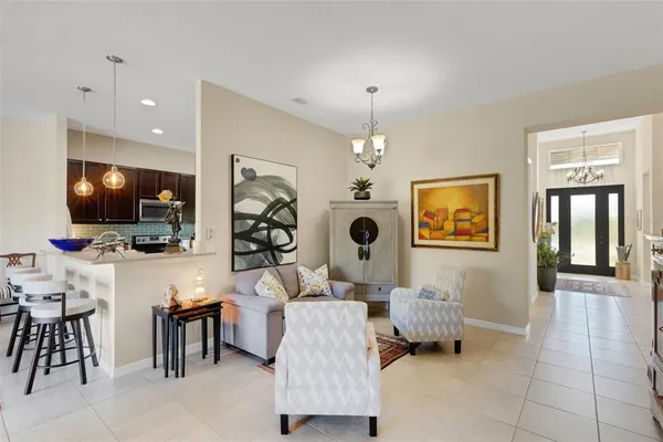 a living room with furniture kitchen view and a flat screen tv