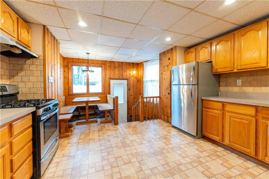 2222 Stuart Street Brooklyn, NY 11229 - Photo 11 of 31 a kitchen with stainless steel appliances granite countertop a refrigerator a stove and wooden cabinets