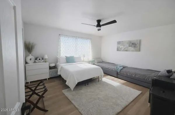 a bedroom with a bed and wooden floor