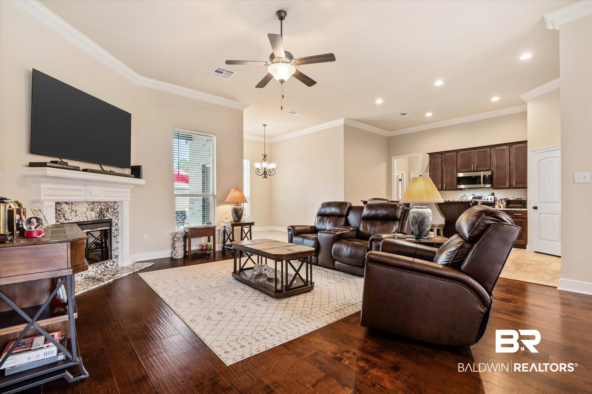 1786 Vivace Drive Foley, AL 36535 - Photo 5 of 21 Living area featuring dark wood finished floors, a premium fireplace, crown molding, ceiling fan, and a chandelier