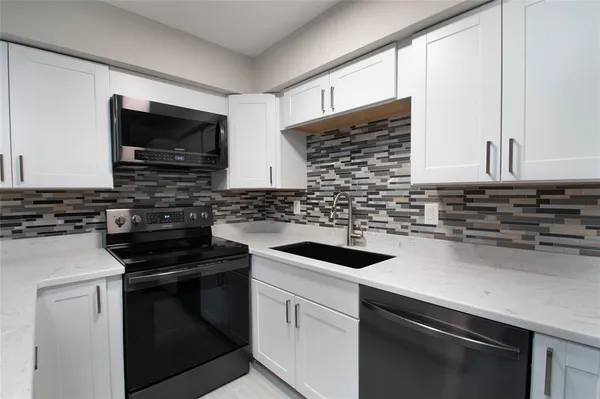 a kitchen with stainless steel appliances a sink stove and microwave