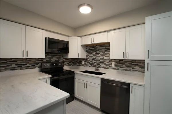 a kitchen with a sink stove and microwave