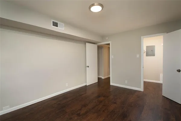 a view of an empty room with wooden floor