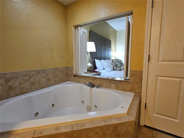 a bathroom with a tub and mirror