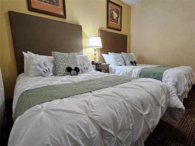 a bedroom with two bed and a lamp