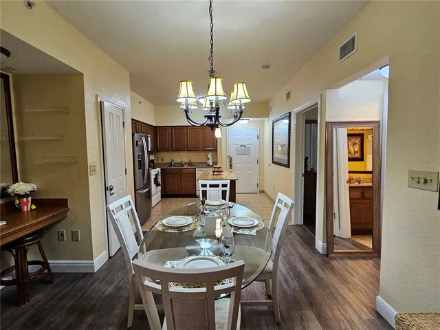 a dining room with furniture a chandelier and wooden floor